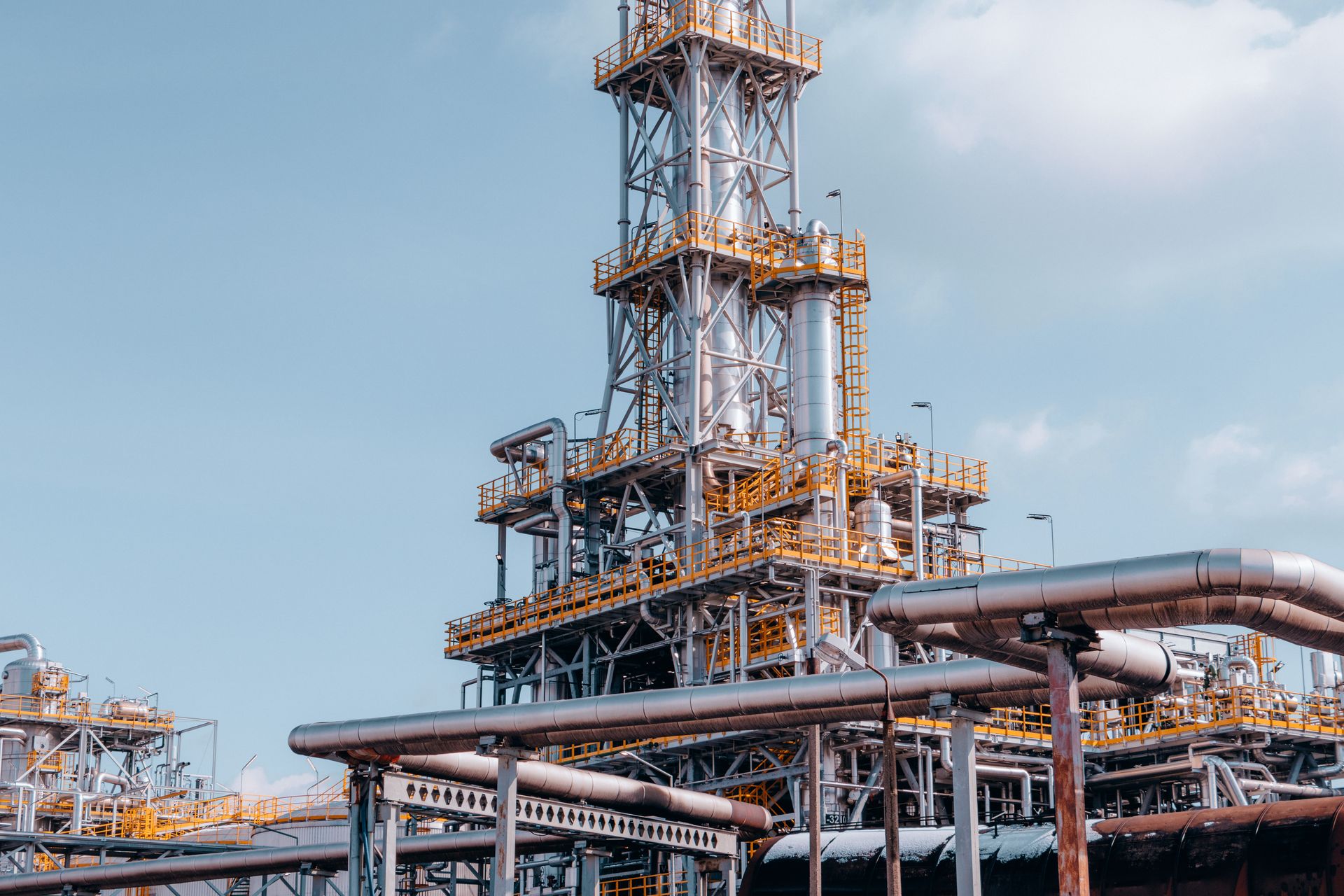 Refinery process towers and pipework against a clear sky